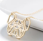 A gold pendant necklace featuring a stylized dog head cutout design, suspended from a delicate gold chain against a clean white background