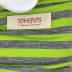 Close-up of a striped knit garment with bright neon green and heather gray horizontal stripes, featuring a cream fabric label that reads 'TOMEPETS I always love you!' in red text.